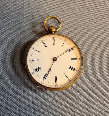 une montre de poche en or avec des chiffres romains sur le cadran