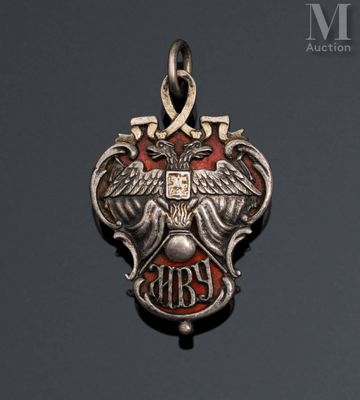 an image of a silver and red pendant with an eagle on it