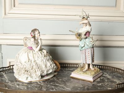 two figurines sitting on a table in a room