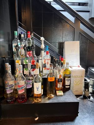 de nombreuses bouteilles d'alcool posées sur un comptoir près d'un escalier