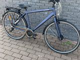 un vélo appuyé contre un mur de briques sur le trottoir