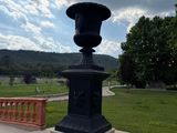a black vase sitting on top of a stone bench