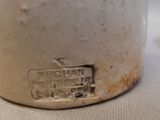 a close up of a white pot with a brown lid