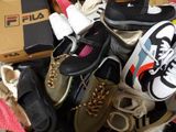 plusieurs paires de chaussures dans une boîte posée sur le sol