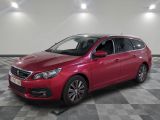 une voiture rouge est garée dans une pièce au sol en damier