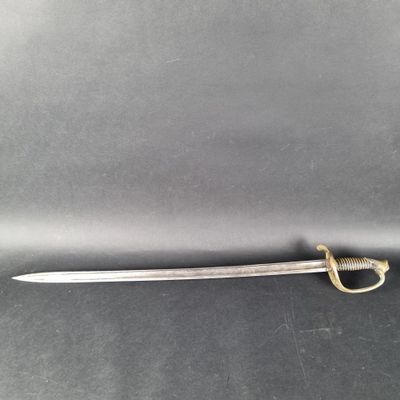 un gros plan d'une épée posée sur une table, sur fond noir