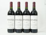 three bottles of wine are lined up on a white surface