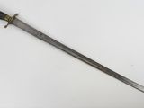 une vieille épée avec un manche en bois sur une surface blanche