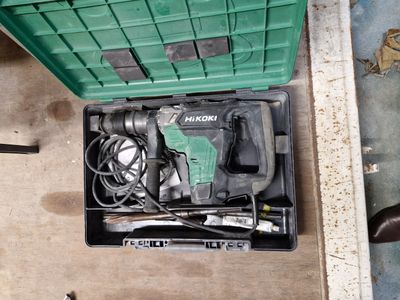 une boîte verte posée par terre, contenant des outils