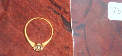 une photo d'une bague en or sertie d'un diamant