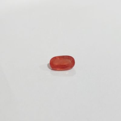 un gros plan d'une pierre rouge sur une surface blanche