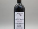 une bouteille de vin rouge posée sur une table blanche