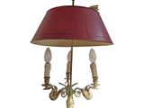 brass table lamp with a red shade on a white background