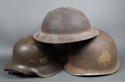 trois casques sont empilés les uns sur les autres sur une surface grise