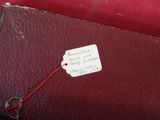 une valise rouge avec une étiquette, posée sur une chaise rouge