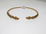 a close up of a gold bracelet on a white surface