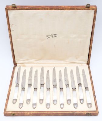 six knives in a wooden case with a white cloth lining