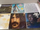several records are stacked on top of each other on a table