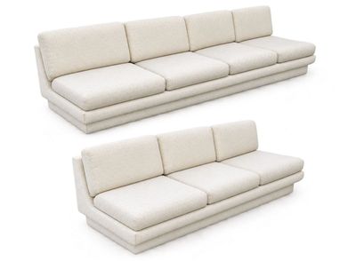 two white couches sitting next to each other on a white surface
