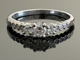 a close up of a diamond ring on a reflective surface
