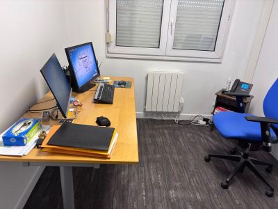 un bureau sur lequel sont posés deux écrans et un ordinateur portable