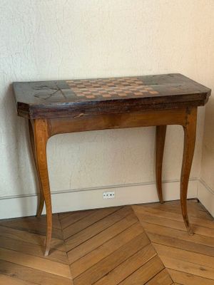 a small wooden table with a checkerboard top on it