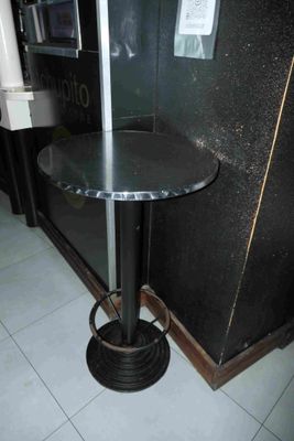 une petite table avec un piètement en métal dans une pièce