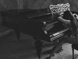 black and white photograph of a woman sitting at a grand piano