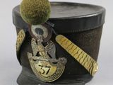a black hat with a green pom pom on it