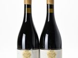 two bottles of wine sitting next to each other on a white surface