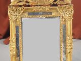 un miroir avec un cadre doré posé sur une table
