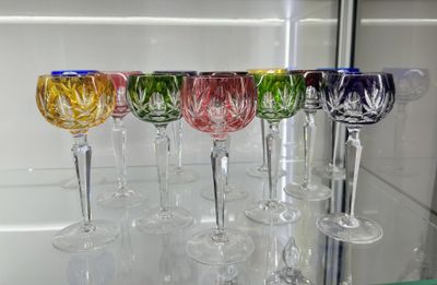 many wine glasses lined up in a row on a shelf