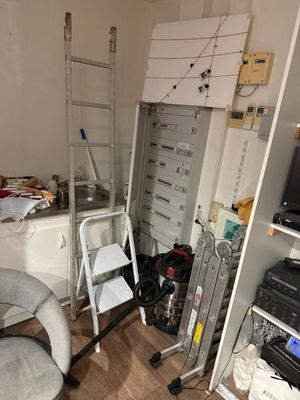 une pièce dans laquelle se trouvent une échelle, une chaise et un téléviseur