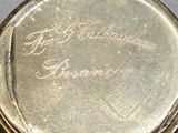 a close up of a silver pocket watch on a table