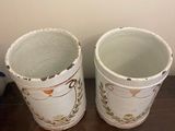 two white vases sitting on a table next to each other