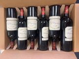 six bottles of red wine in a cardboard box on a table