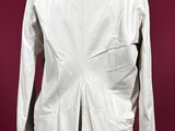 a white jacket on a mannequin stand against a red background