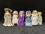 sept poupées en porcelaine de différentes couleurs et tailles sur un fond noir