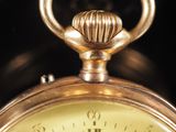 a close up view of a gold clock with roman numerals