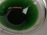 a green liquid in a glass bowl with a black lid