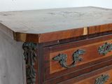 a wooden chest of drawers with a marble top