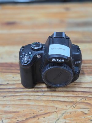 a black camera sitting on a wooden table