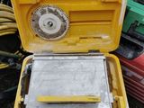 une boîte jaune contenant un outil, posée par terre