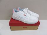 white sneakers with pink soles on top of a red box