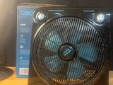 un ventilateur posé sur une table à côté d'une lampe