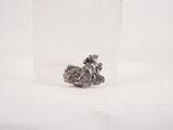 a small piece of silver on a white surface