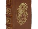 un vieux livre marron avec un motif doré sur la couverture