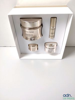 une boîte ouverte contenant un ensemble de produits de soins de la peau, posée sur une surface blanche