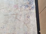 a very old rug on the floor next to a dresser
