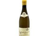 the bottle of white wine is sitting on a white surface